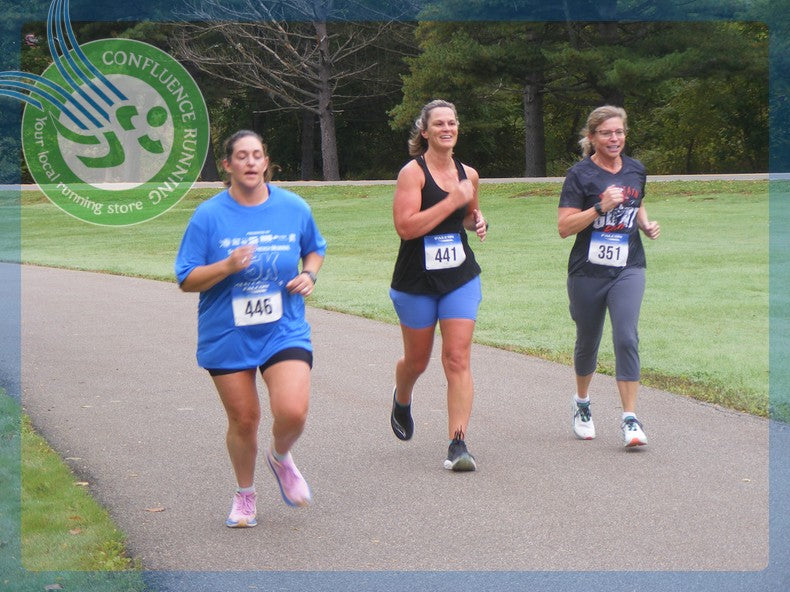 Three runners wearing bibs 446, 441 and 351 race together on the Otsiningo Park path at the 2026 Meals on Wheels 5K.